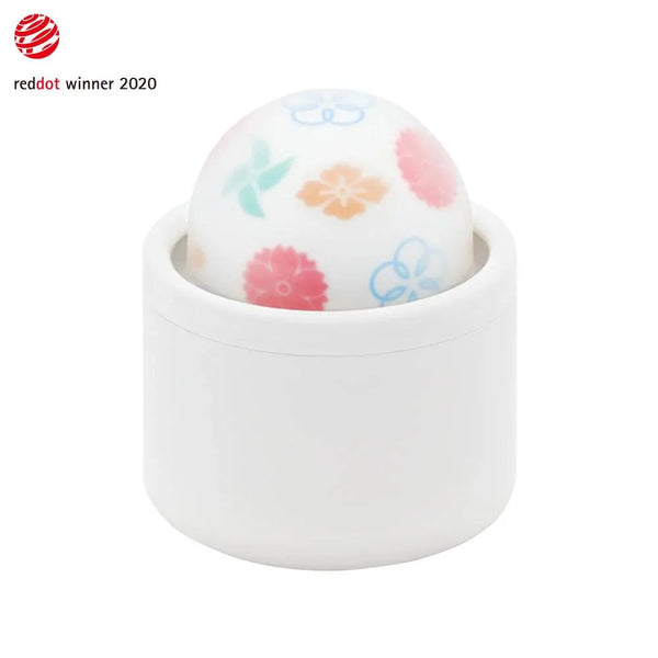 Iroha Temari KAZE vibrator with floral-patterned silicone ball resting in white ceramic-style holder, Red Dot Award 2020