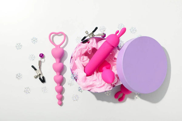 Dreamy Desire Flirty Fun Box with pink silicone toys and nipple clamps in lavender gift box