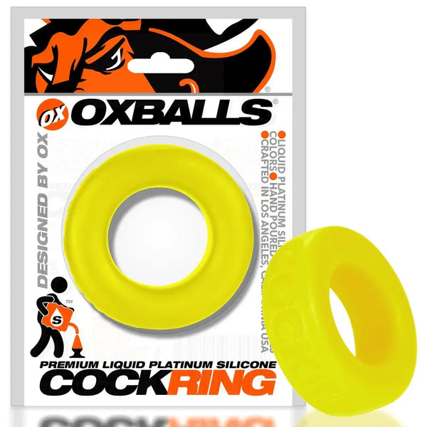 Acid yellow COCK-T cockring displayed beside its Oxballs retail card packaging for scale
