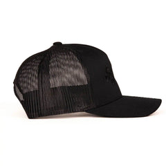 All-black trucker hat side profile revealing breathable mesh back and small embroidered side logo