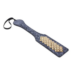 Angled view of the Cougar Studded Paddle showing gold stud diamond pattern and wrist loop strap