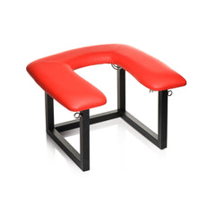 Angled view of red vegan leather queening chair showing U-shaped cushion and sturdy frame