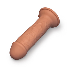 Angled side view of Girth dildo laying flat, showing full shaft length and base