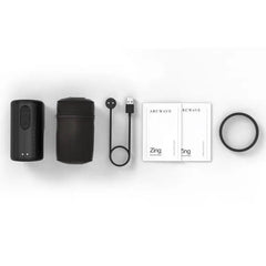 Arcwave Zing full kit laid flat: stroker body, cap, magnetic USB charging cable, manuals, and cock ring