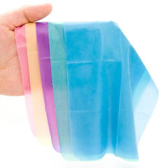 Assorted flavored dental dams fanned in hand showing thin, translucent latex in multiple pastel colors
