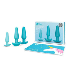 b-Vibe Anal Training & Education Set showing teal plugs beside retail box and complete guide to anal play booklet