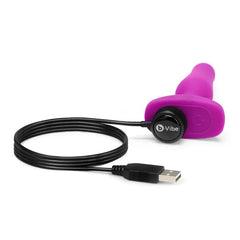 b-Vibe Novice Plug connected to magnetic USB charging cable, side profile view