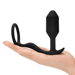 b-Vibe Snug & Tug black silicone plug with cock ring resting on open palm