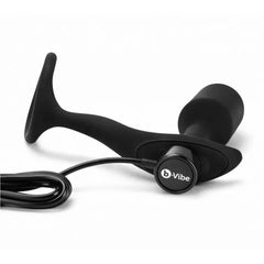 Close-up of b-Vibe Snug & Tug showing magnetic USB charging cable connected to plug base