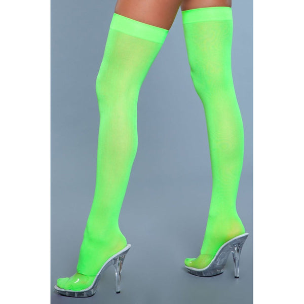 Be Wicked! neon green opaque nylon thigh highs shown from a rear three-quarter angle on clear heels