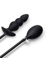 Close-up of beaded silicone plug and squeeze-bulb pump with chrome release valve, flat lay