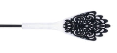 Close-up of black filigree lace silicone paddle tip with white flexible shaft base