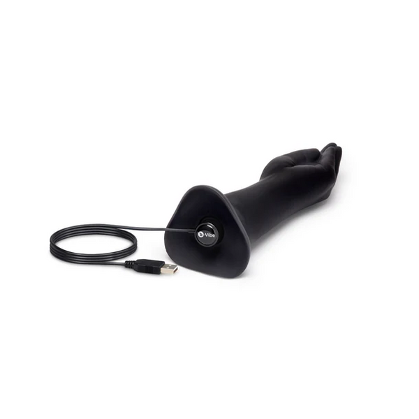 Black fisting dildo lying flat with USB magnetic charging cable attached to the base