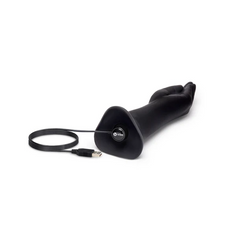 Black fisting dildo lying flat with USB magnetic charging cable attached to the base