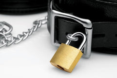 Close-up of black leather cuff buckle secured with a brass padlock and silver chain