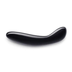 Black obsidian Crystal G Wand lying flat, showing smooth curved shaft and polished finish