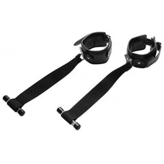 Close-up of black padded cuff restraints with locking buckles and adjustable nylon door straps
