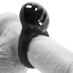 Black silicone cock ring with rounded vibrating head shown fitted on a model ring for scale