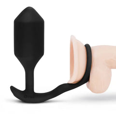 Black silicone plug and cock ring combo shown on anatomical model for fit reference