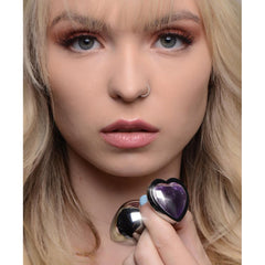 Blonde model holding the Booty Sparks amethyst heart plug close to her face, showing gem detail