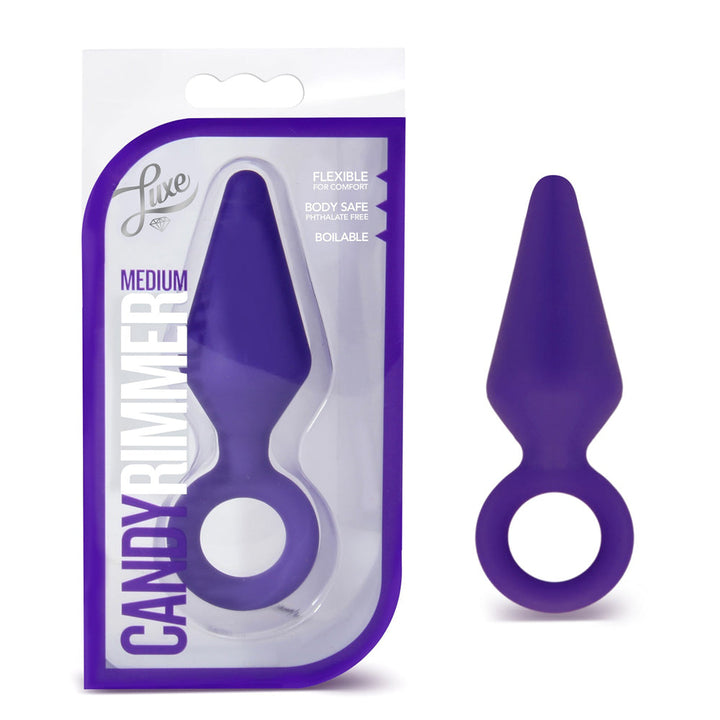 Blush Luxe Candy Rimmer Medium in purple silicone, shown in packaging beside the plug
