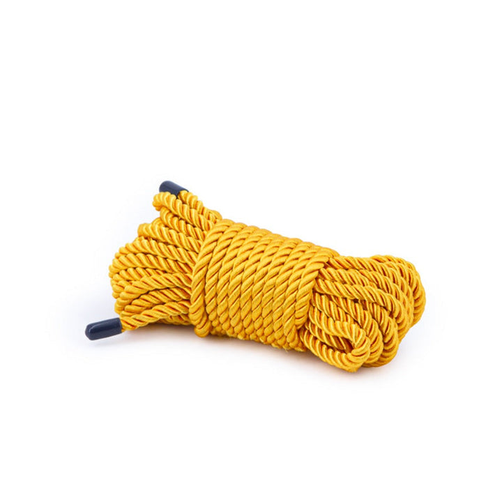 Bondage Couture gold twisted nylon rope coiled with navy-tipped ends on white background