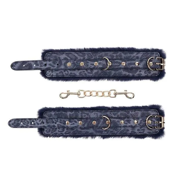 Both navy fur cuffs unclasped and laid flat beside detachable gold link connecting chain