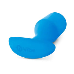 Bottom angle of blue b-Vibe Snug Plug 5 showing curved anchor base with brand logo embossed