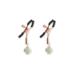 Close-up of Bound G4 rose gold nipple clamps featuring knurled adjustment screws and clover charms