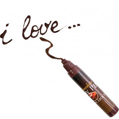 Chocolate Body Pen uncapped, writing 'i love...' in smooth milk chocolate ink on white surface