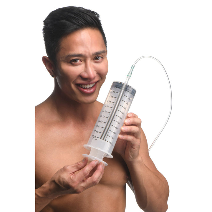 CleanStream 550ml Enema Syringe with flexible silicone tube, held by smiling male model