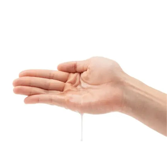 Clear organic lubricant pooled in an open palm, showing smooth, lightweight texture