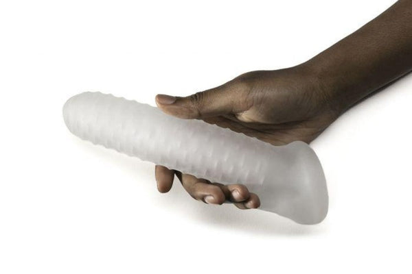 Clear textured penis sheath held in hand, showing flexible ribbed surface and full 7.5" length