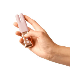Compact Le Wand Deux blush pink vibrator held in one hand, showing its travel-friendly slim size