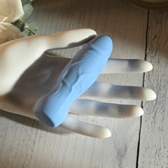 Compact Lil Buddy vibrator resting across a display hand, showing realistic textured shaft detail