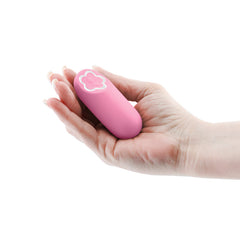 Compact pink bullet vibrator resting in an open palm, showing its travel-friendly size