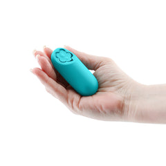 Compact teal NS Novelties Harmony bullet vibrator resting in an open palm, showing size