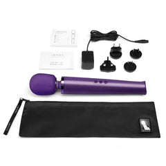 Complete Le Wand kit laid flat showing massager, charger, adapters, storage bag, and user guides