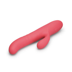 Coral pink rabbit vibrator horizontal view emphasizing flexible clitoral arm and smooth finish