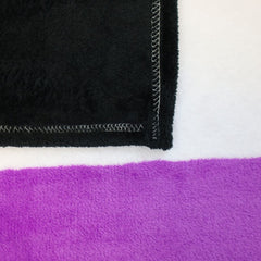Corner detail of asexual pride blanket showing overlock stitched edge on black and purple fleece