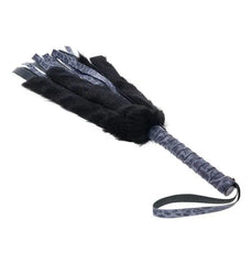 Close-up of Cougar Flogger showing wrapped leopard-print handle and wrist loop detail