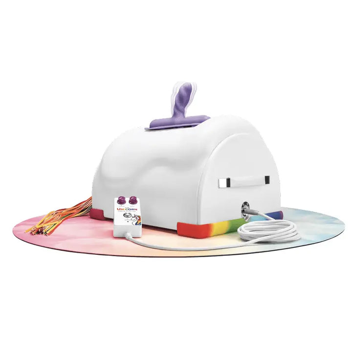 The Cowgirl Unicorn Premium Riding Sex Machine in white with rainbow mat, purple horn handle, and hose attachment