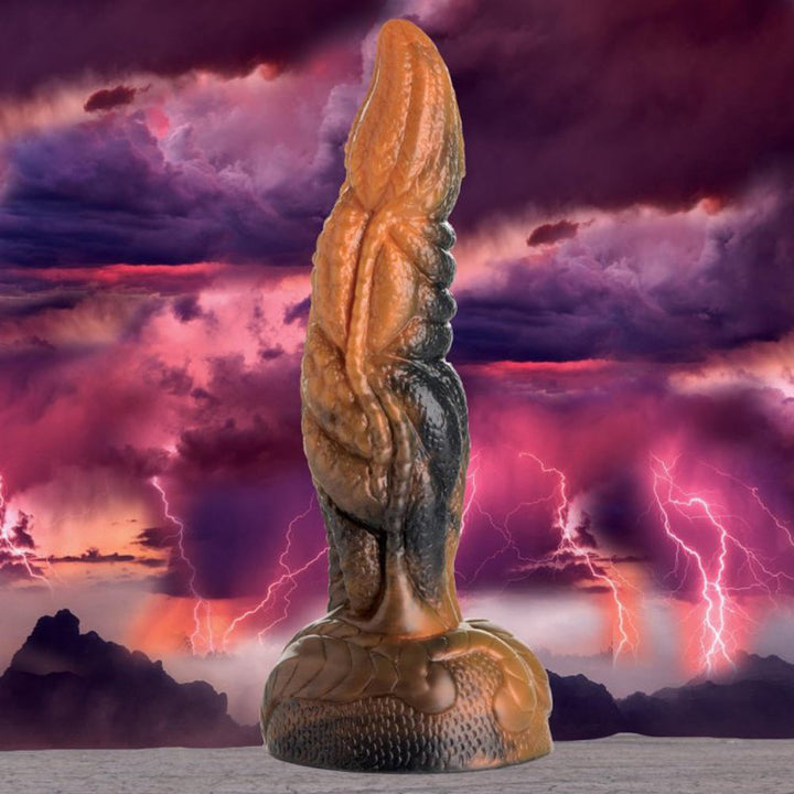Creature Cocks Ravager tentacle silicone dildo in amber and black against stormy sky backdrop