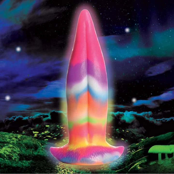 Creature Cocks Unicorn Kiss glow-in-the-dark silicone dildo glowing against a cosmic night sky