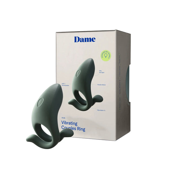 Dame Hug vibrating couples ring displayed upright beside its retail packaging for scale reference