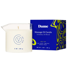Dame Massage Oil Candle beside royal-blue box showing Lime Leaves, Ambrette & White Peach scent