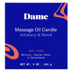Close-up of Dame Massage Oil Candle packaging showing Soft Touch scent notes and net weight