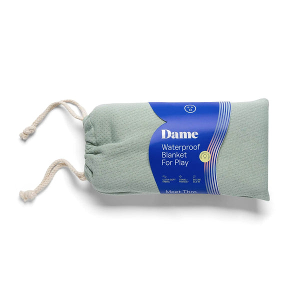 Dame Waterproof Blanket For Play in sage green, rolled and stored in its drawstring bag