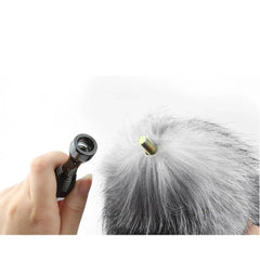 Detachable screw connection between metal plug stem and grey faux fur fox tail shown close up