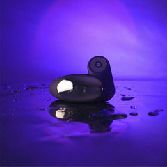 Dorcel Perfect Lover couples vibrator resting on wet reflective surface under purple ambient lighting